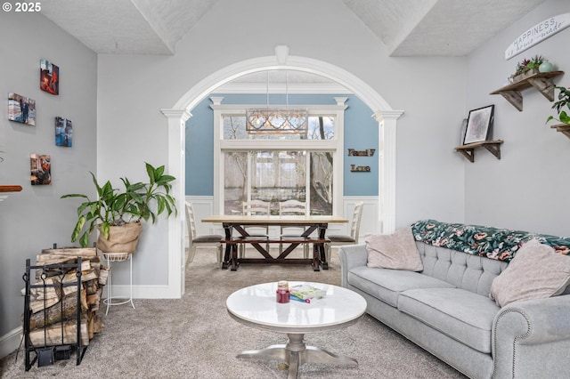 living area with carpet floors, wainscoting, and ornate columns