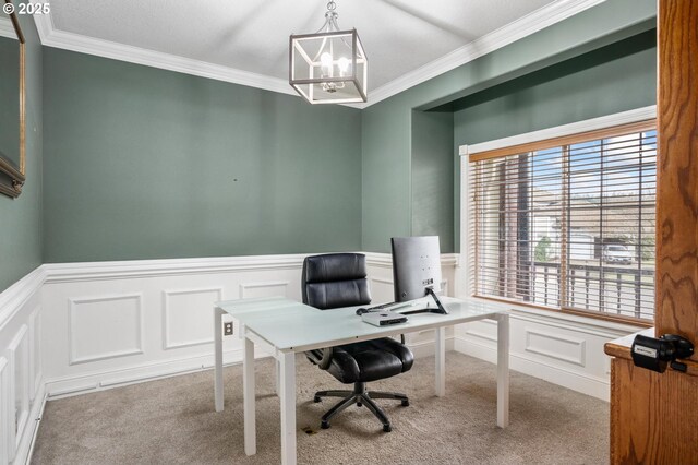 carpeted home office featuring a wainscoted wall, a chandelier, and crown molding