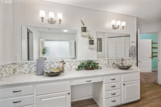 bathroom featuring vanity, wood finished floors, and tasteful backsplash