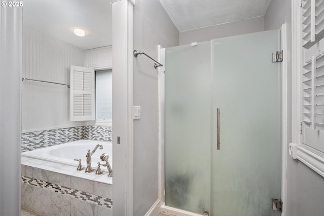 bathroom featuring a stall shower and a garden tub