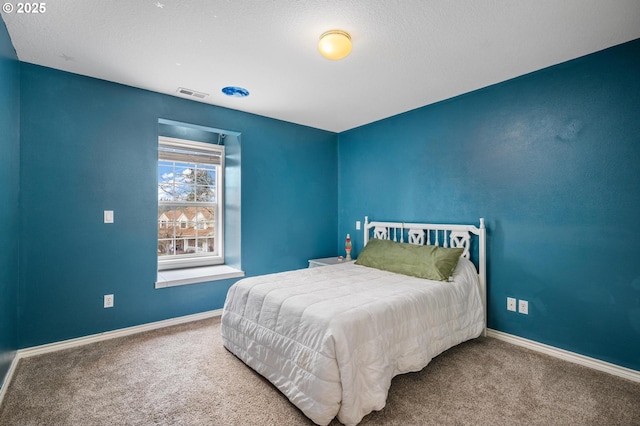 carpeted bedroom featuring visible vents and baseboards