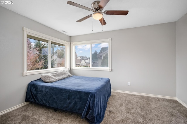 bedroom featuring visible vents, a ceiling fan, baseboards, and carpet floors