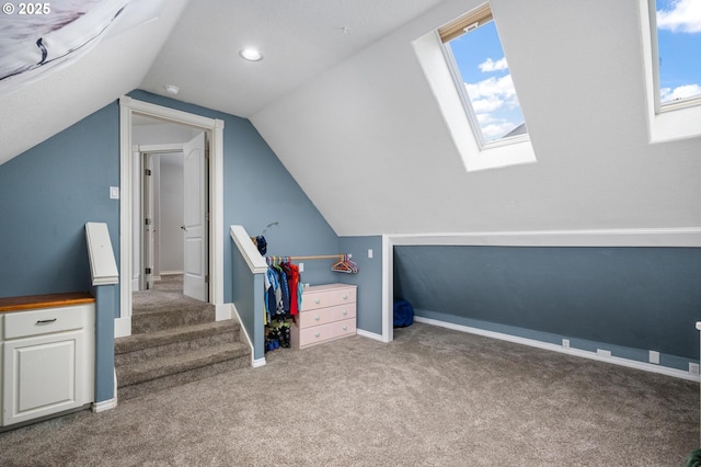 additional living space featuring vaulted ceiling with skylight, baseboards, plenty of natural light, and carpet flooring
