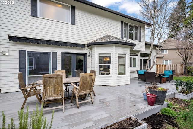 wooden deck with outdoor dining space, french doors, and fence