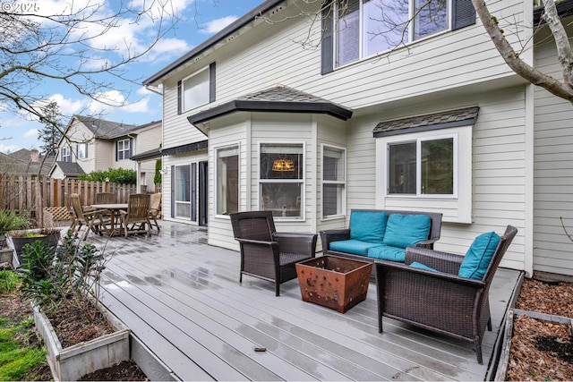 deck with an outdoor living space, outdoor dining space, and fence