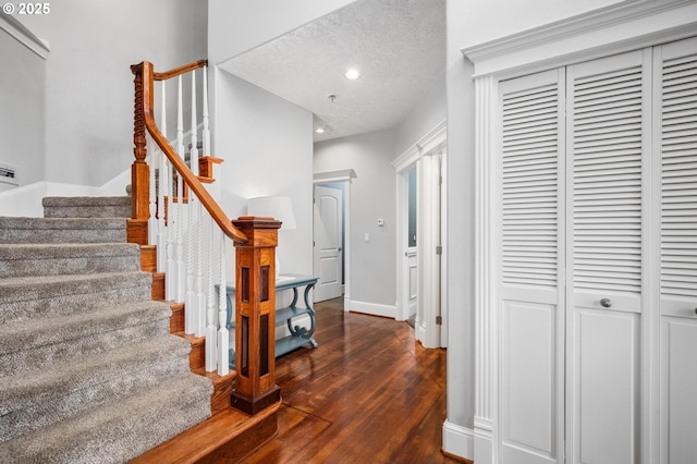 entrance foyer featuring a textured ceiling, dark wood finished floors, recessed lighting, stairway, and baseboards