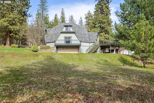 exterior space with a wooden deck, stairway, an attached garage, and a lawn