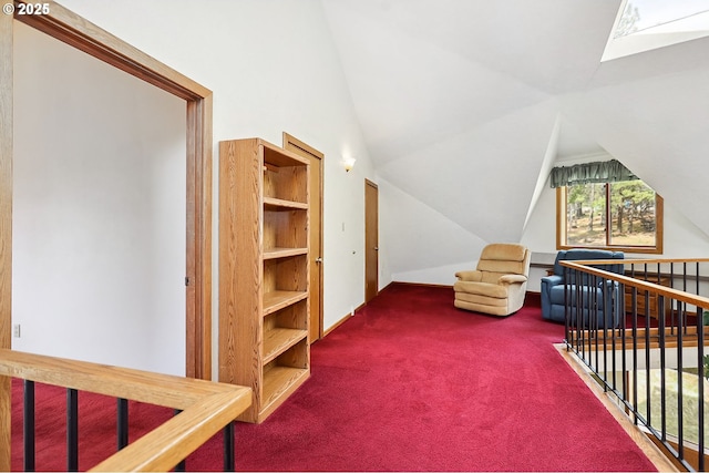 interior space featuring lofted ceiling with skylight, an upstairs landing, and carpet floors