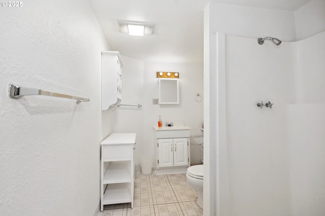 bathroom with toilet, a shower, and vanity