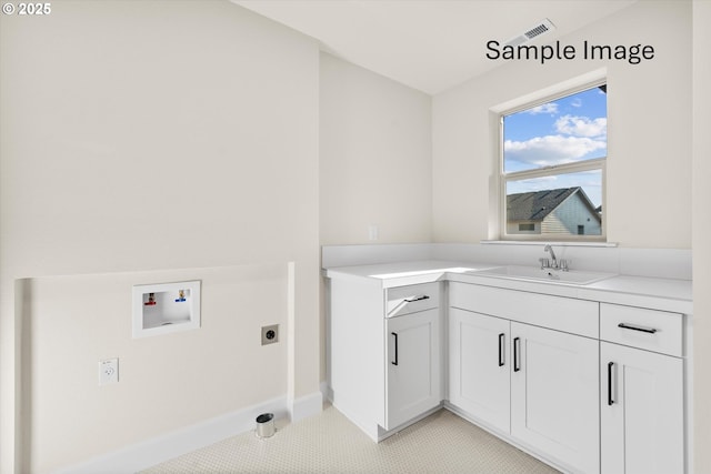 washroom featuring washer hookup, electric dryer hookup, cabinet space, and baseboards