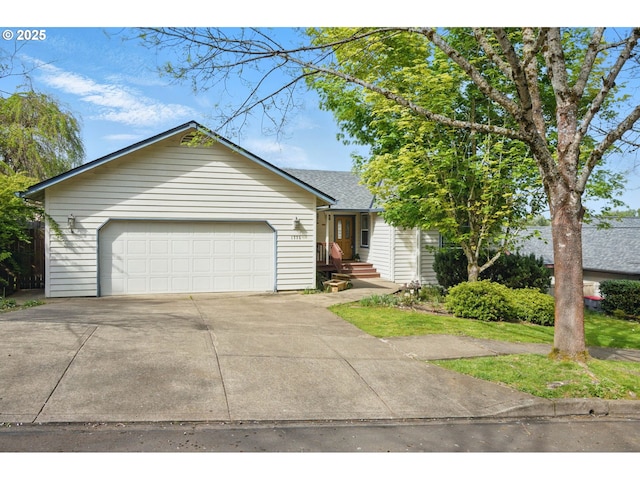 ranch-style house with a shingled roof, an attached garage, and concrete driveway