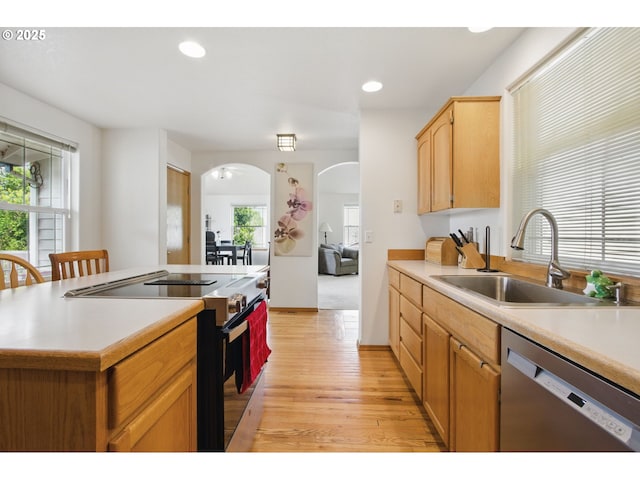 kitchen featuring stainless steel dishwasher, light countertops, electric range oven, arched walkways, and a sink