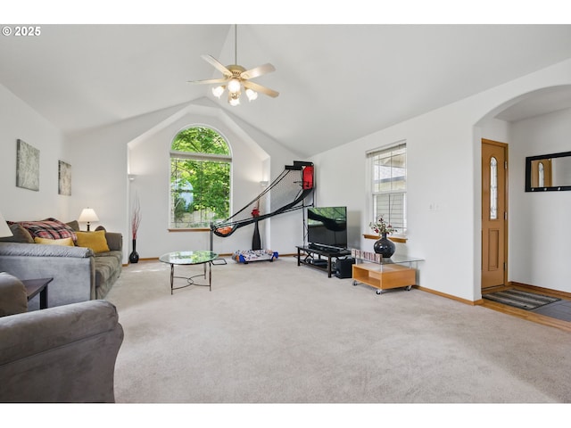 carpeted living room with arched walkways, a ceiling fan, a healthy amount of sunlight, and lofted ceiling