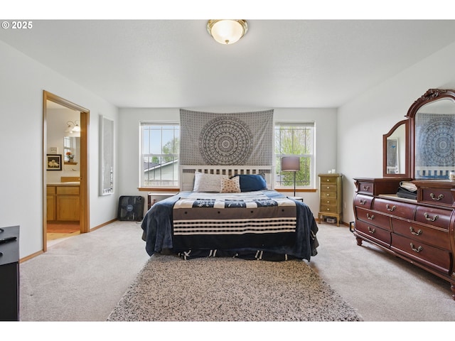 bedroom featuring carpet floors, baseboards, and ensuite bath