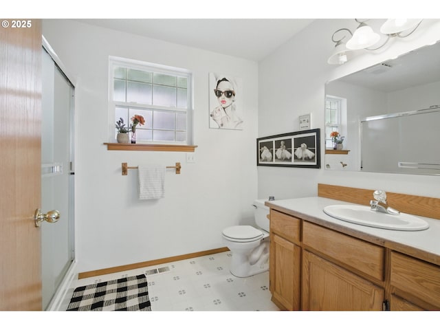 bathroom with a stall shower, vanity, baseboards, tile patterned floors, and toilet