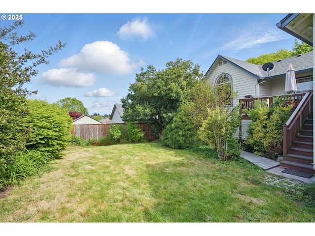 view of yard featuring stairs, fence, and a wooden deck