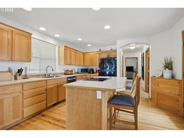 kitchen with a center island, fridge, a sink, stainless steel microwave, and black cooktop