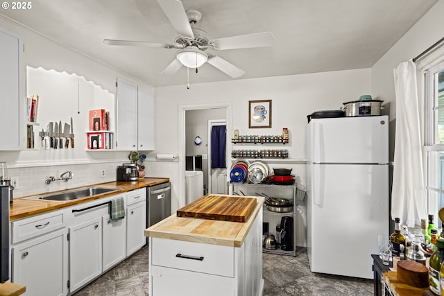 9746 SE Woodstock Blvd, Portland, OR 97266 - kitchen featuring butcher block counters, freestanding refrigerator, independent washer and dryer, a sink, and white cabinetry