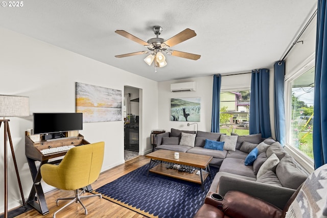 9746 SE Woodstock Blvd, Portland, OR 97266 - living area featuring an AC wall unit, wood finished floors, a ceiling fan, and a textured ceiling