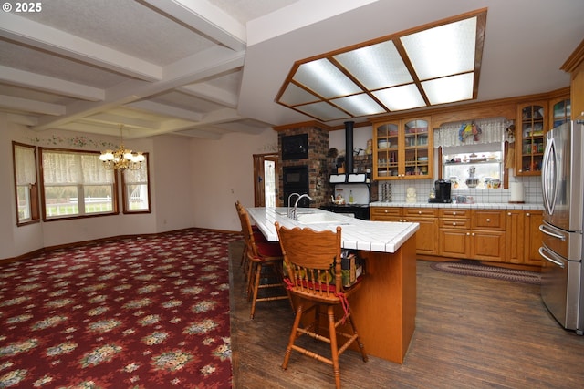 1397 State Route 506, Vader, WA 98593 - kitchen with freestanding refrigerator, a chandelier, a kitchen bar, brown cabinets, and tile counters