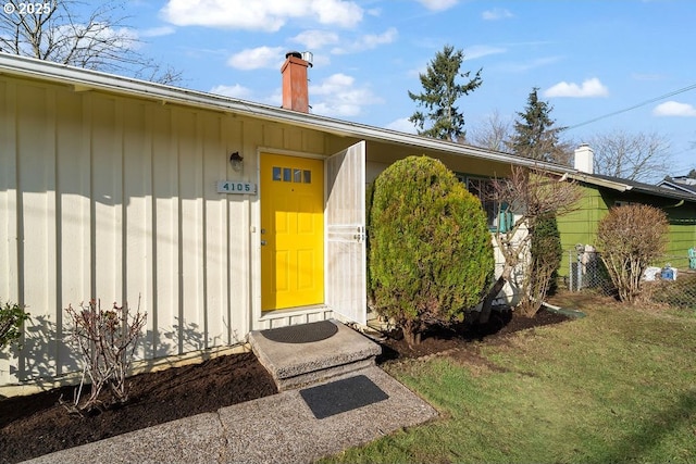 view of exterior entry featuring a yard