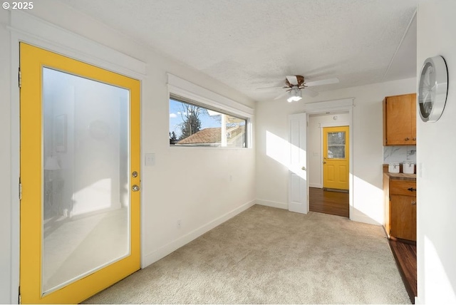 spare room with ceiling fan, light carpet, and a textured ceiling