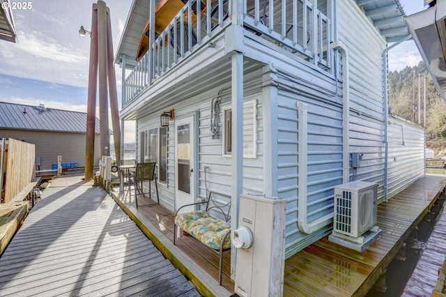 wooden terrace featuring ac unit and outdoor dining area