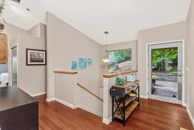 entrance foyer featuring dark wood-type flooring, plenty of natural light, baseboards, and lofted ceiling