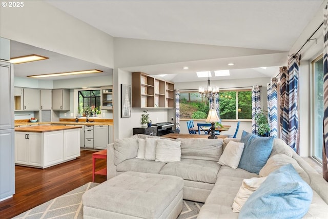 living area featuring vaulted ceiling, a chandelier, dark wood-style floors, and recessed lighting