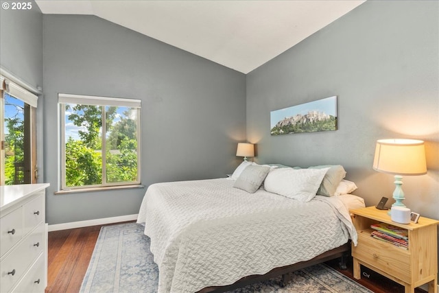 bedroom with dark wood-style flooring, baseboards, and high vaulted ceiling