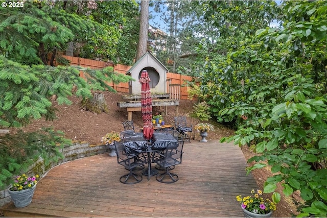 deck with a fenced backyard and outdoor dining space