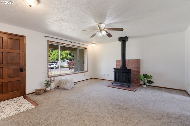 15605 SE 5th St, Vancouver, WA 98684 - unfurnished living room with carpet flooring, ceiling fan, a wood stove, and a textured ceiling