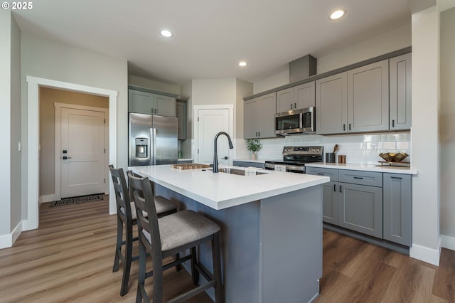 4027 SW Myrtle Aly Unit 7, Gresham, OR 97030 - kitchen with appliances with stainless steel finishes, gray cabinetry, a sink, and tasteful backsplash