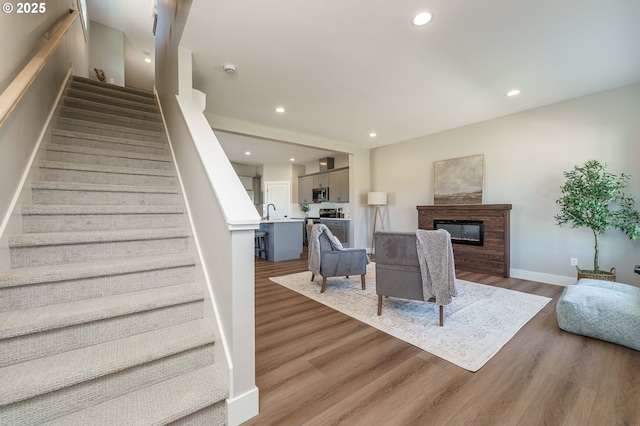 4027 SW Myrtle Aly Unit 7, Gresham, OR 97030 - living room featuring a glass covered fireplace, wood finished floors, recessed lighting, and stairs