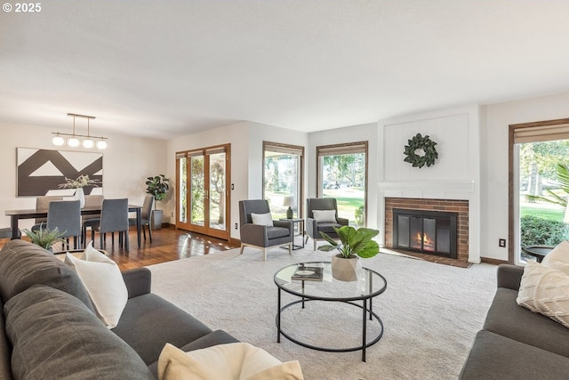 living room with a wealth of natural light, hardwood / wood-style flooring, and a brick fireplace