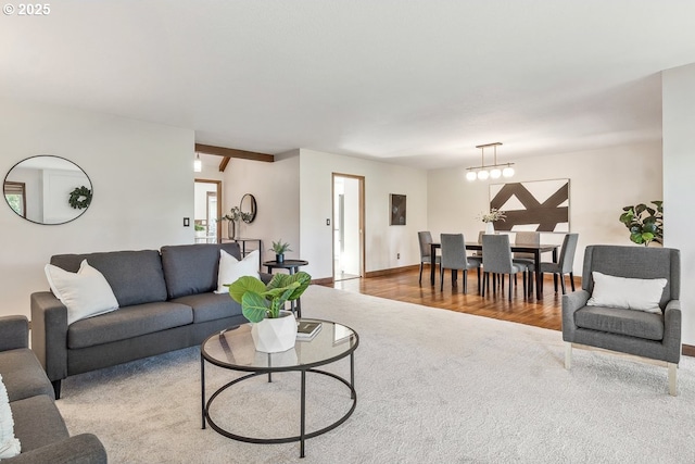 living room with beam ceiling, a chandelier, and wood-type flooring