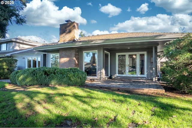 back of property featuring french doors and a yard