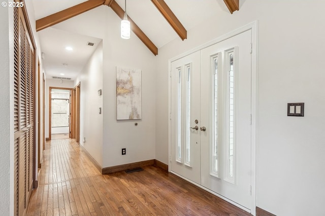 foyer entrance featuring lofted ceiling with beams and hardwood / wood-style flooring