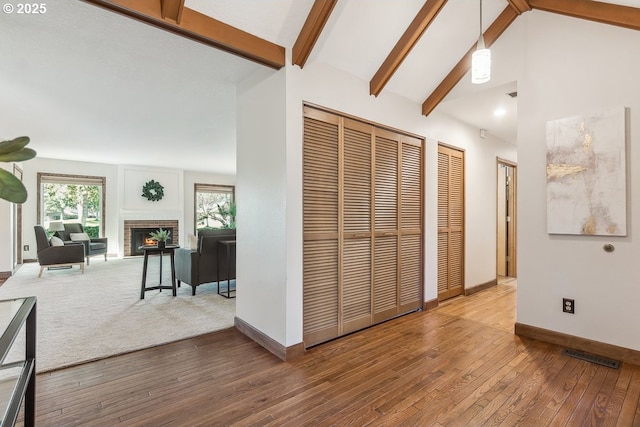 hall featuring hardwood / wood-style floors and vaulted ceiling with beams