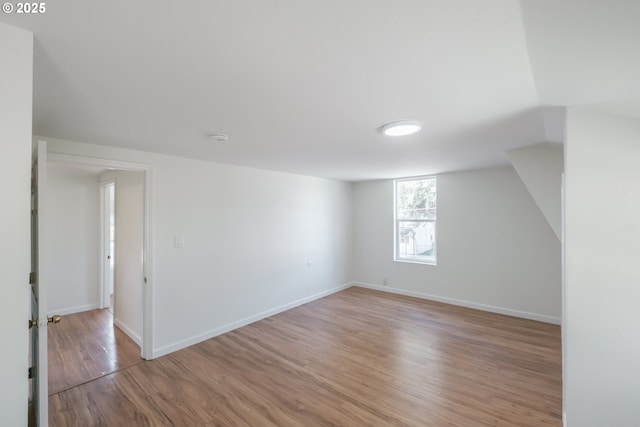 additional living space featuring light wood-type flooring and baseboards
