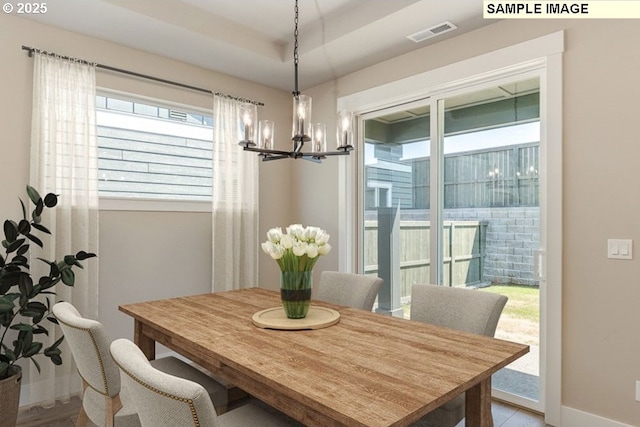 dining room featuring a notable chandelier, baseboards, and visible vents