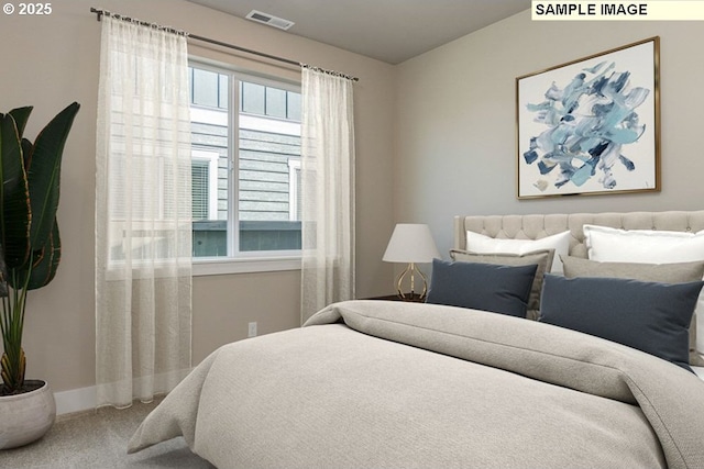 carpeted bedroom with visible vents and baseboards