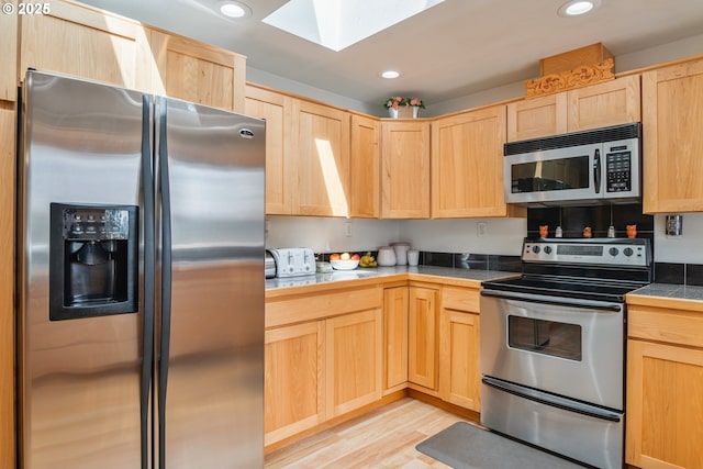 220 Plomondon Rd, Toledo, WA 98591 - kitchen with light wood-style floors, light brown cabinets, a skylight, and stainless steel appliances