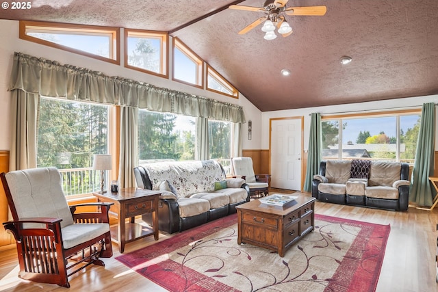 220 Plomondon Rd, Toledo, WA 98591 - living area featuring light wood-style floors, vaulted ceiling, a ceiling fan, and wainscoting