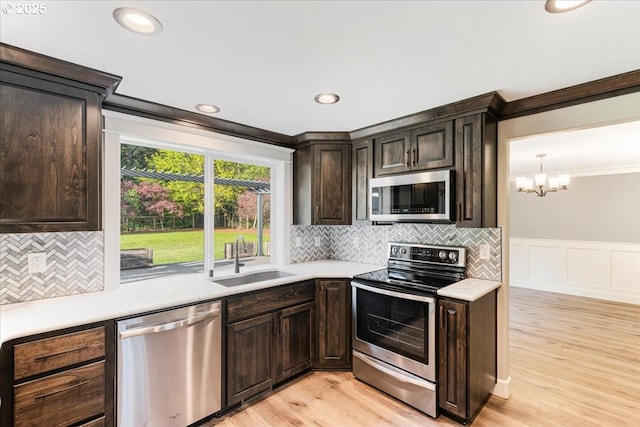 20606 NE 229th St, Battle Ground, WA 98604 - kitchen with ornamental molding, dark brown cabinetry, light countertops, a sink, and stainless steel appliances