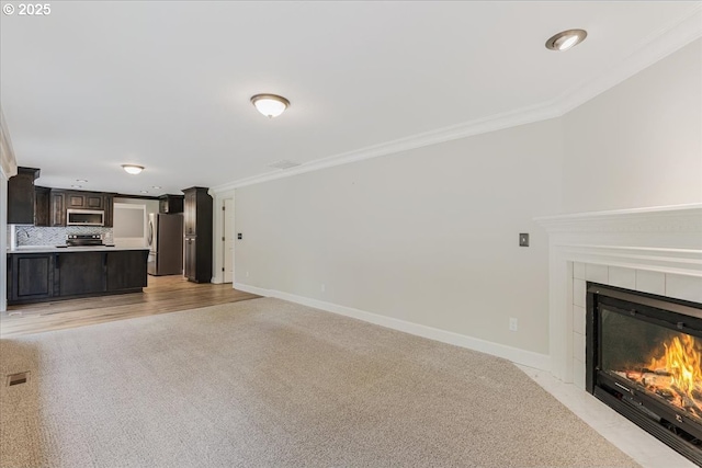 20606 NE 229th St, Battle Ground, WA 98604 - unfurnished living room featuring baseboards, a tiled fireplace, ornamental molding, and light carpet