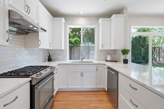 14067 Chatham Ct, Lake Oswego, OR 97035 - kitchen with stainless steel appliances, under cabinet range hood, healthy amount of natural light, white cabinets, and recessed lighting