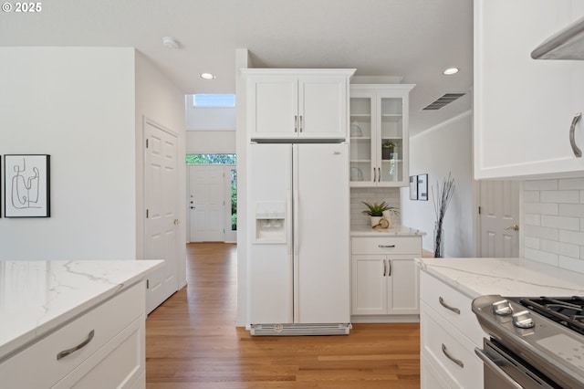 14067 Chatham Ct, Lake Oswego, OR 97035 - kitchen with white fridge with ice dispenser, recessed lighting, glass insert cabinets, white cabinets, and backsplash