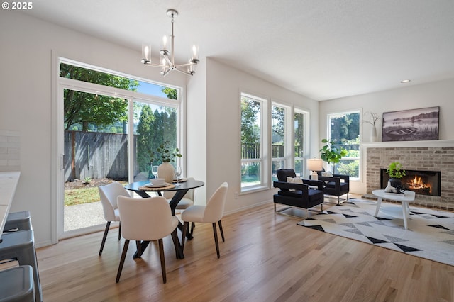 14067 Chatham Ct, Lake Oswego, OR 97035 - dining room with wood finished floors, a chandelier, a brick fireplace, and recessed lighting