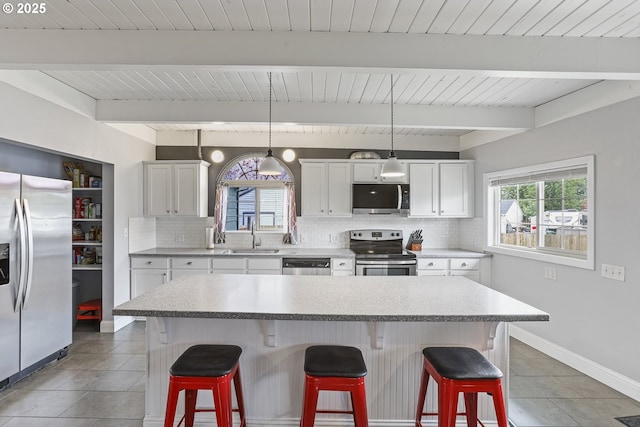 2064 Tualatin St, Saint Helens, OR 97051 - kitchen with appliances with stainless steel finishes, backsplash, a kitchen breakfast bar, and a wood ceiling with exposed beams